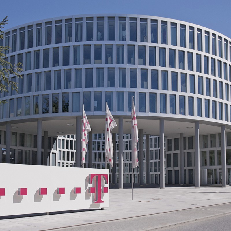 rundes Gebäude mit Glasfront und Logo der Telekom