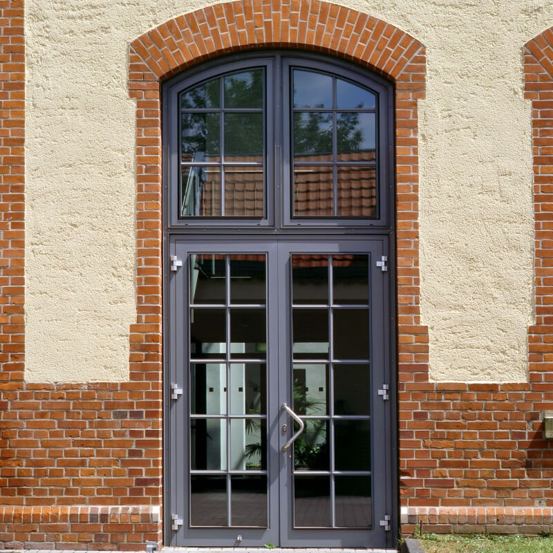 Hohe Eingangstür, metallgefasstes Glas